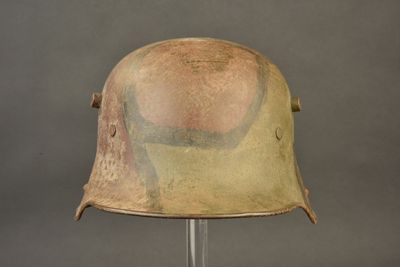 an old helmet on a stand on a gray background
