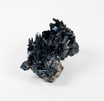 a small piece of black crystals on a white surface