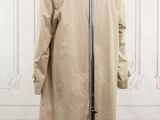 the back view of a beige trench coat on a mannequin stand