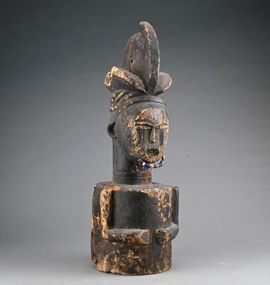 une vieille statue en bois d'un homme avec un chapeau sur la tête