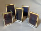 four different sized picture frames are arranged in a row on a table