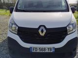 the front of a white van parked in a gravel lot
