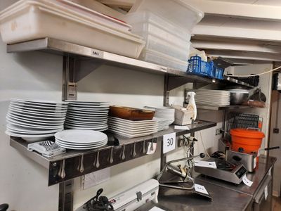 beaucoup d'assiettes et de casseroles sur les étagères de la cuisine