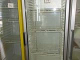 un réfrigérateur à porte vitrée dans un magasin, avec une étiquette de prix dessus