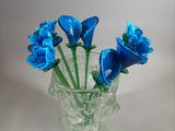 a glass vase with blue flowers in it on a table