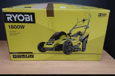 un carton contenant une tondeuse à gazon posé sur une table en bois