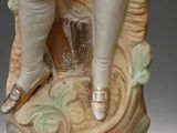 a figurine of a man and a woman sitting on a tree stump