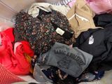 a pile of clothes that is sitting on a bed