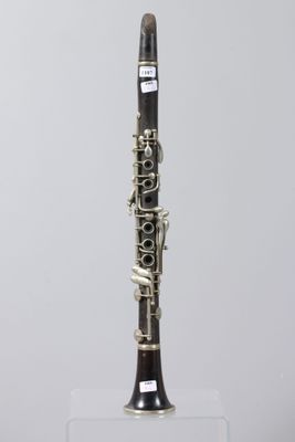 a close up of a clarinet on a clear stand on a white background