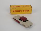 dinky toy car and box of dinky toys on a white surface