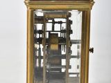 a gold clock that is sitting on a white surface