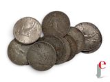 some silver coins are stacked on top of each other on a white surface