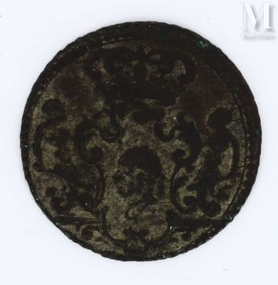 an old coin with a design on it sitting on a white surface