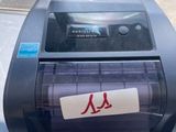 the printer is sitting on the table in front of the window