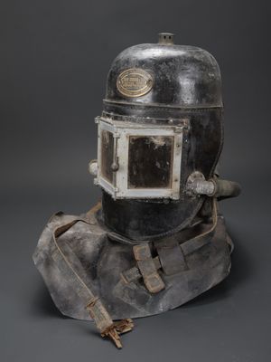un gros plan d'un casque posé sur un rocher, sur fond gris