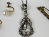 a silver necklace with pearls and other jewelry on a table