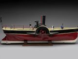 a model of a steam powered boat on a wooden stand