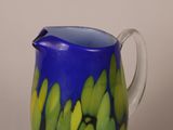 a blue and green vase with yellow flowers on it