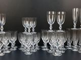 twelve wine glasses lined up in a row on a black surface