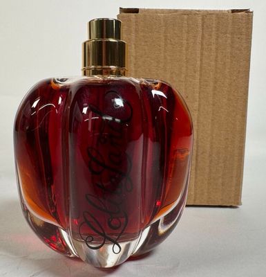 un flacon de parfum posé à côté d'une boîte en carton