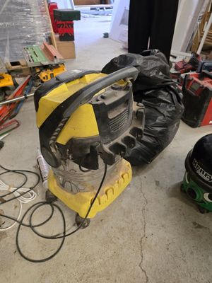 une machine jaune et noire dans un garage, à côté d'autres outils