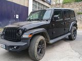 une jeep noire garée devant un immeuble