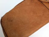a brown bag with a handle sitting on a white surface