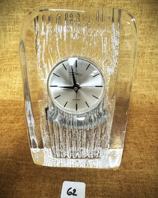 une horloge en verre posée sur une table