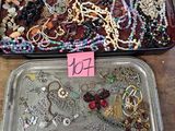 two trays of jewelry on a table with a price tag