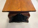 a wooden table with a black base and a brown top