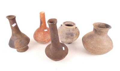 cinq vases posés sur une surface blanche