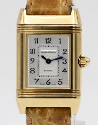 an image of a close up of a wrist watch with a gold case