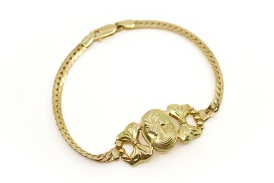 gros plan d'un bracelet en or sur fond blanc