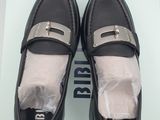 they are two pairs of black loafers with silver buckles on them