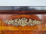 a wooden chest of drawers with a gold decoration on it