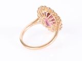 a close up of a pink sapphire and diamond ring on a white background