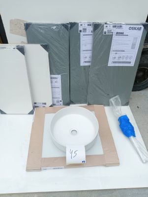 a white bowl sitting on top of a table next to some boxes