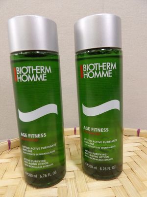 two bottles of biotherm home age fitness lotion sitting on a basket