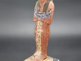 une statue égyptienne représentant un homme coiffé d'un chapeau