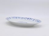 a white bowl with blue flowers on it sitting on a table