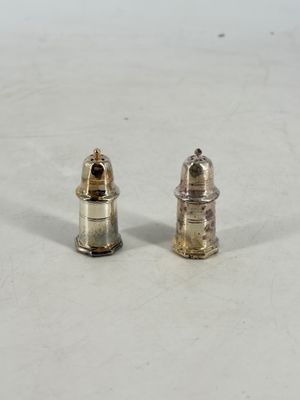 pair of silver salt and pepper shakers on a white surface