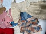 a pile of clothes that is sitting on a bed