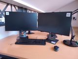 two computer monitors on a desk with a keyboard and mouse
