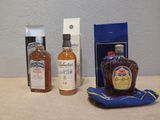 trois bouteilles d'alcool posées sur une table à côté d'un sac bleu