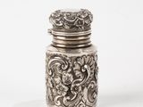 a silver jar with a lid on a white surface