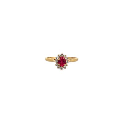 a gold ring with a red stone surrounded by white diamonds