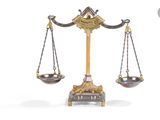 une balance en or sur laquelle sont posés deux bols en argent