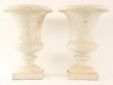 two white vases sitting next to each other on a white surface