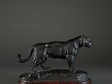 a bronze statue of a cheetah on a wooden base
