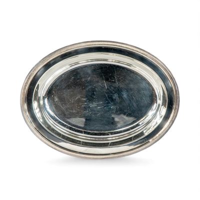 une assiette en argent sur fond blanc avec un reflet